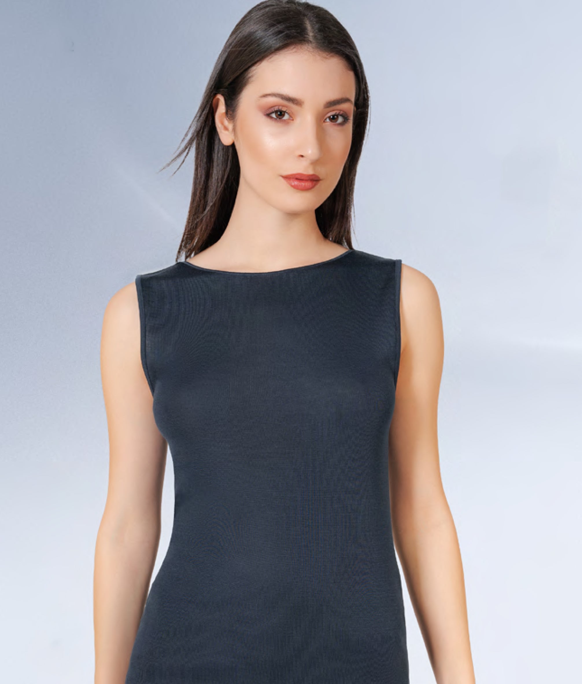 Woman wearing a black sleeveless dress against a light gray background