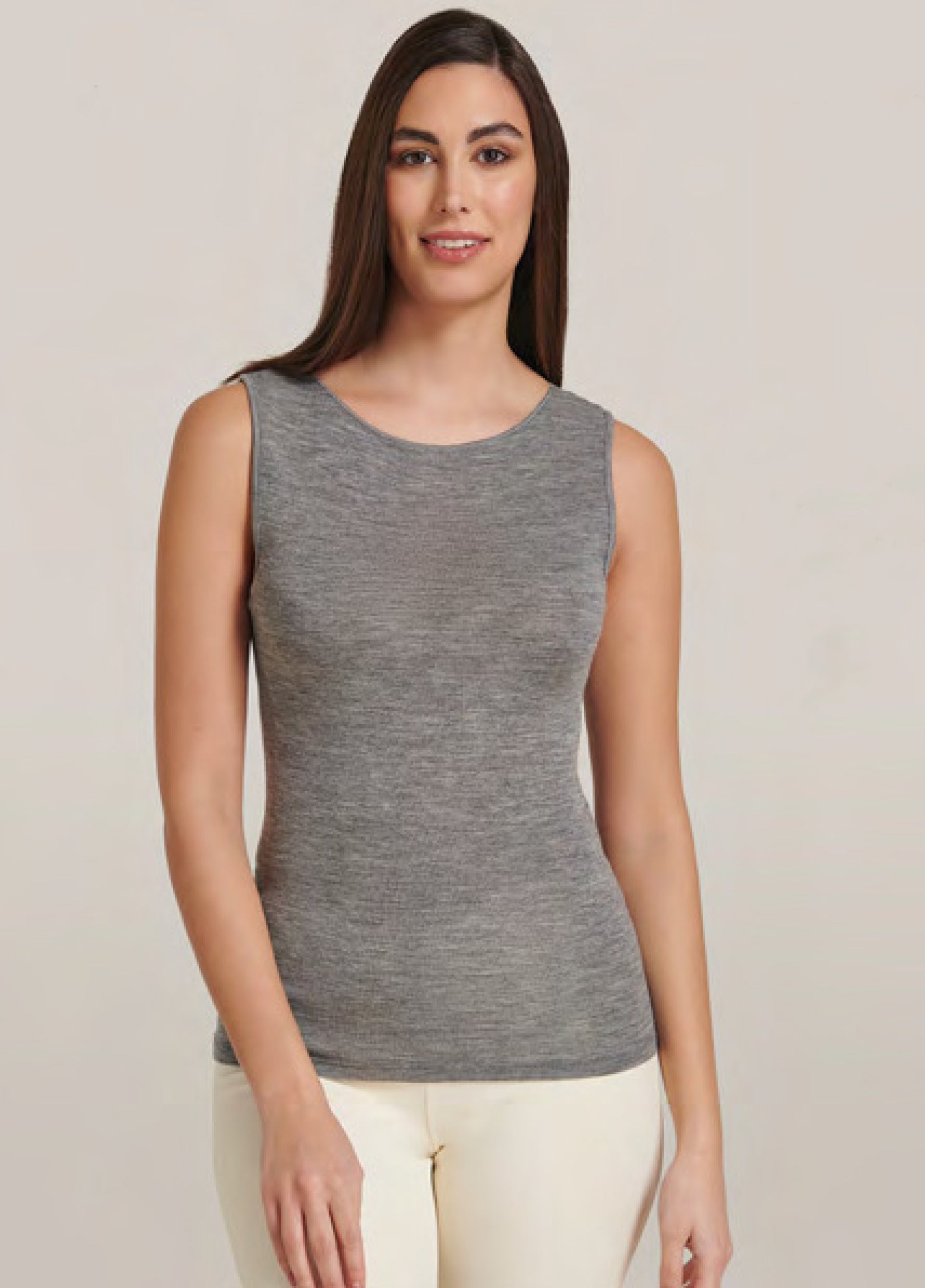 Woman wearing a gray sleeveless top against a plain background