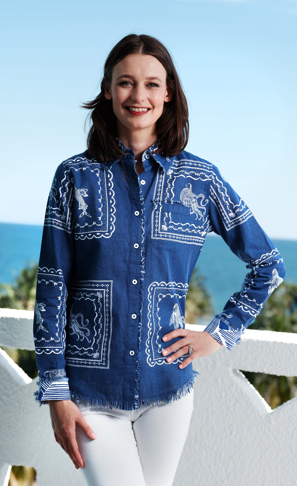 woman on balcony with ocean in the background