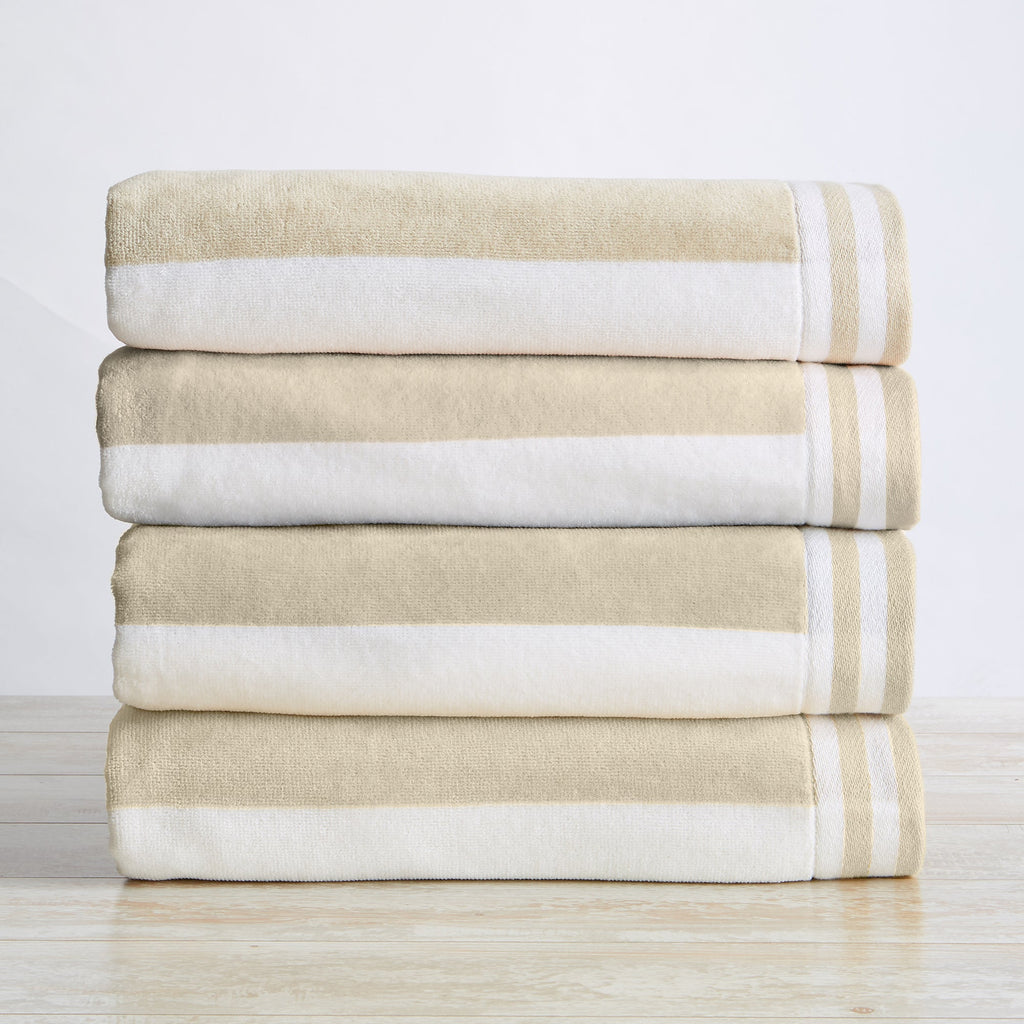 Stack of beige and white striped towels on a light wooden surface with a white background