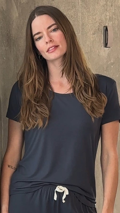 Woman wearing a dark blue outfit against a neutral background