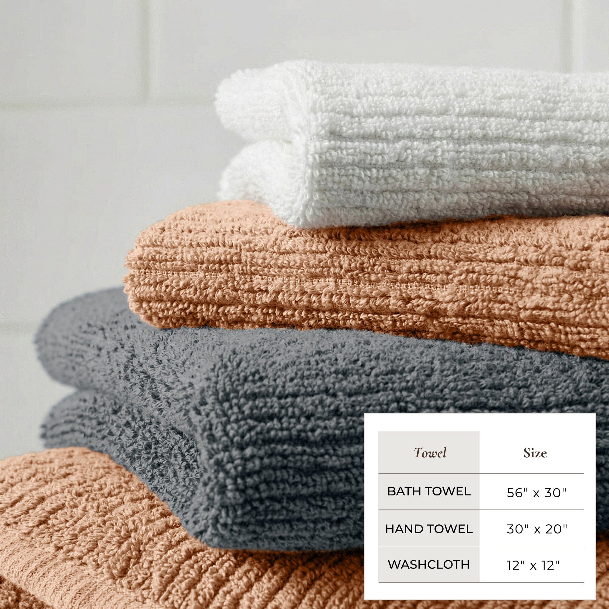 Stack of towels in various colors with size chart on a light gray background