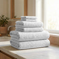 Stack of gray towels on a marble countertop in a bathroom setting