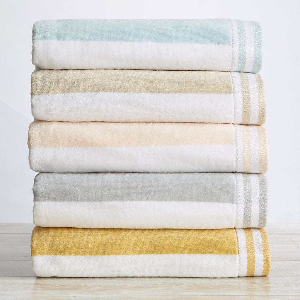 Stack of folded towels in various colors on a light background